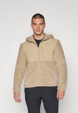 Fleece jacket in beige with a textured, furry body, solid fabric front, zip closure, and hood; features a chest pocket and side seams.