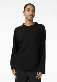 Maglione nero a maniche lunghe con scollo rotondo e vestibilità comoda. Realizzato in tessuto morbido, presenta maniche ampie e un design minimalista.