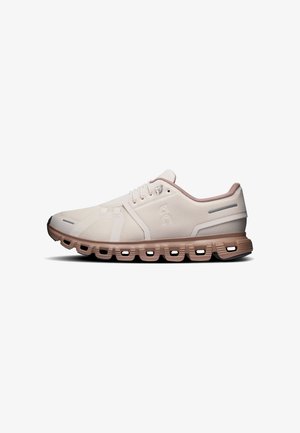 Chaussure de sport beige clair avec tige en mesh, fermeture à lacets et semelle segmentée marron conçue pour l’amorti et la flexibilité.
