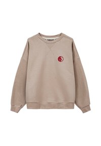 Beżowa bluza wykonana z miękkiego materiału, z okrągłym dekoltem i oversize'owym krojem, z czerwonym okrągłym logo na klatce piersiowej oraz ściągaczami na rękawach.