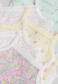 Nałożone na siebie prążkowane topy z cienkimi ramiączkami z drobnymi kwiatowymi wzorami w pastelowej zieleni, żółci, bieli oraz wielobarwne, z białą lub żółtą lamówką.