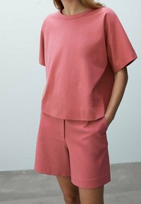 Roze katoenen T-shirt met een ronde hals en korte mouwen, gecombineerd met bijpassende shorts met een losse pasvorm en zijzakken.