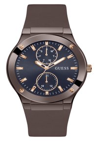 Montre avec un bracelet en silicone marron et un cadran bleu marine. Présente des index horaires dorés, trois sous-cadrans et un boîtier métallique. Nom de la marque affiché.