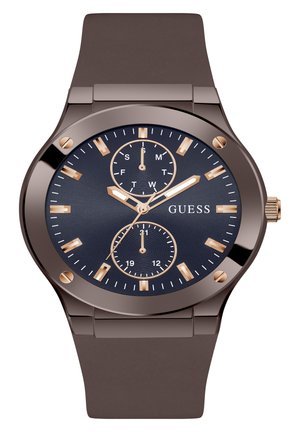 Brauner Silikonarmband-Uhr mit blauer Zifferblatt. Mit goldfarbenen Stundenmarkierungen, drei Unterdials und einem metallischen Gehäuse. Markenname sichtbar.