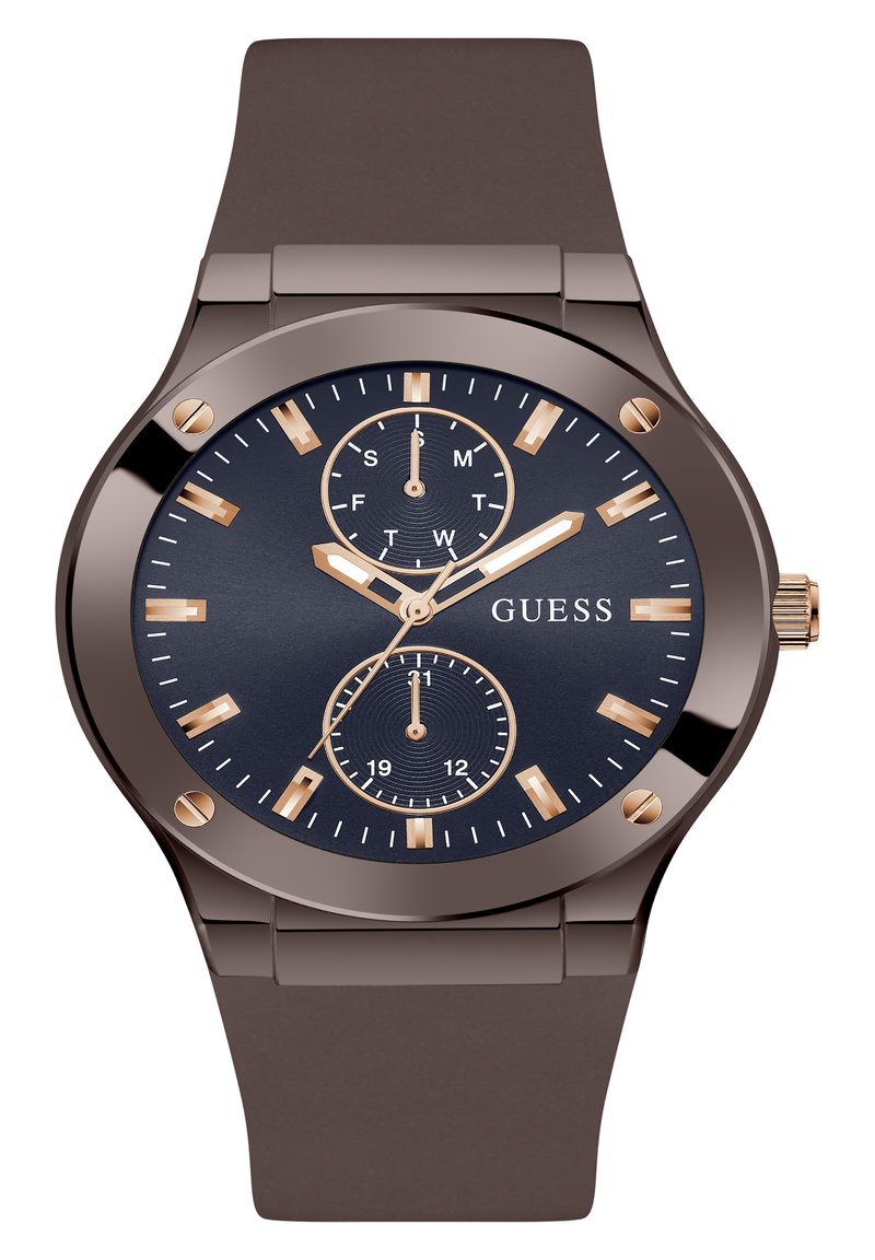 Montre avec un bracelet en silicone marron et un cadran bleu marine. Présente des index horaires dorés, trois sous-cadrans et un boîtier métallique. Nom de la marque affiché.