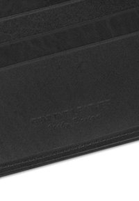 Czarny skórzany portfel z gładką fakturą, wieloma kieszeniami na karty oraz tłoczonym napisem "Genuine Leather". Szwy wykończone.