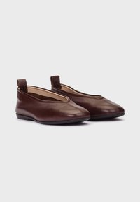 Brown leather shoes with a low profile, rounded toe, and sloped sides. Features a small heel and two fabric loops for easy wearing.