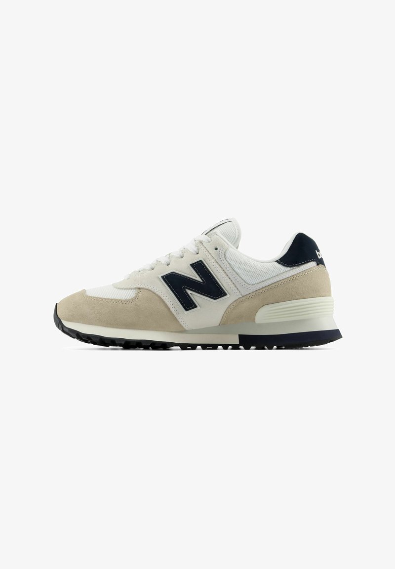 Άσπρο και μπεζ αθλητικό παπούτσι New Balance με μαύρο λογότυπο "N" και μαύρη σόλα, από τη εξωτερική πλευρά σε λευκό φόντο.