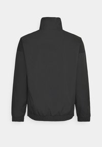 Svart bomberjacka med hög krage, elastiska muddar och nederkant, samt slätt, lätt tyg. Enkelt design utan synliga mönster.