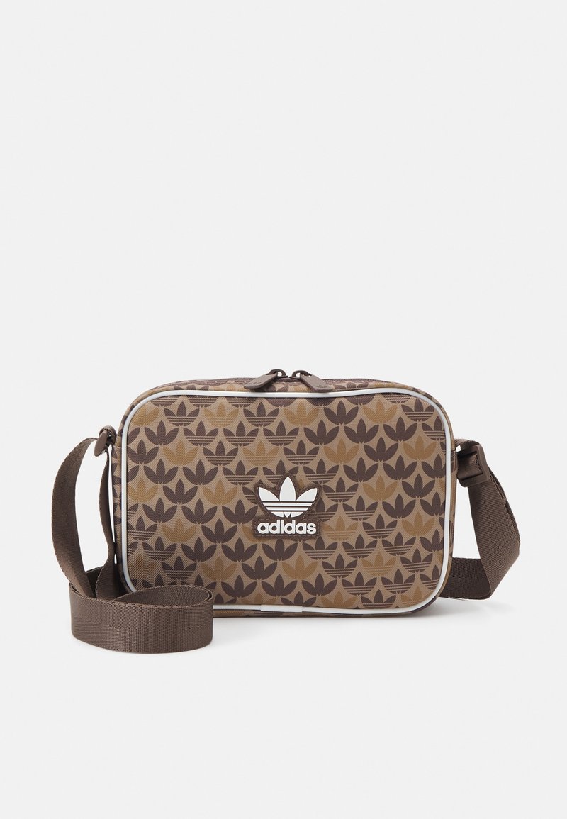 Brązowa torba o wzorze w kształcie prostokąta, z regulowanym paskiem i białym logo Adidas z przodu. Teksturowany materiał z gładkim wykończeniem.