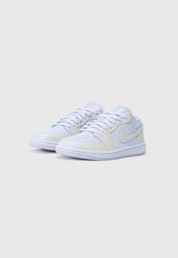 Adidași albi cu un finisaj din piele netedă, model cu șireturi, vârf perforat și un logo texturat în formă de swoosh pe lateral.