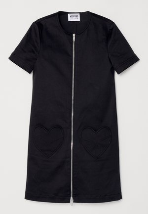 Mustam kootud lühikeste varrukatega kleit, millel on ees tõmblukk, kaks südamekujulist taskut, millel on läbiv õmblusdetail, ja ümmargune kaelus. Valmistatud puuvillast.