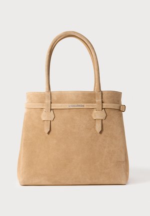 Beige suède totebag met twee handvatten, voorzien van een vlakke bovenkant, gestikte accenten en een logodetail aan de voorkant. Soepele textuur.