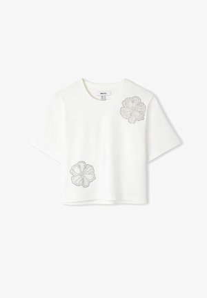 Witte cropped t-shirt van katoen, met twee met rhinestones versierde bloemontwerpen op de voorkant. Korte mouwen en ronde halslijn.