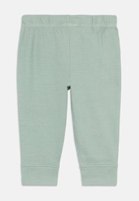 Leggings en coton vert clair avec une taille élastique. Design ajusté, avec des jambes à ourlets et une texture lisse. Pas de motifs visibles ni de matériel.