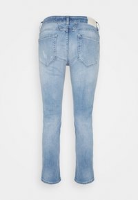 Vaqueros de mezclilla azul claro con ligero desgaste en los bolsillos traseros, corte recto y cintura visible con trabillas para cinturón.