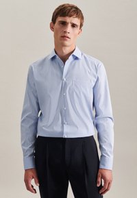 Lichtblauw geblokt overhemd van katoen, met een button-down kraag, lange mouwen en een borstzak. Gecombineerd met donkere broek.