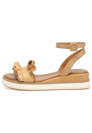 Tan leather sandal with ruffled front design, ankle strap with buckle, and cushioned platform sole featuring a white midsole.