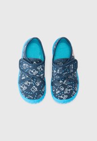 Blå slip-on skor med mörkblått tyg som har vita mönster av byggfordon, säkrade med en klickrem, med en strukturerad gummisul.