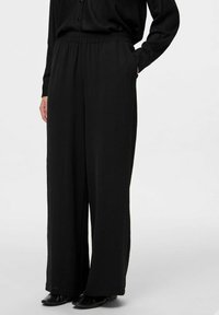 Črne široke hlače z elastiko v pasu, izdelane iz lahkotnega materiala, z teksturiranim zaključkom in stranskimi žepi.