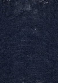 Σκούρο ναυτικό μπλε πλεκτό ύφασμα με πυκνή υφαντή υφή που δείχνει διακριτικές παραλλαγές στο μοτίβο της πλέξης.