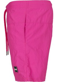 Shorts da bagno rosa realizzati in materiale leggero, dotati di una vita elastica con cordoncino e una fessura laterale per facilitare i movimenti.
