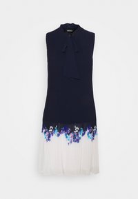 Robe sans manches avec un corsage côtelé bleu marine, un détail noué au niveau de l'encolure et une jupe plissée blanche ornée de motifs floraux en bleu et violet.