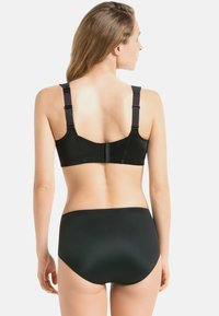 Czarna bielizna składająca się z gładkiego biustonosza z regulowanymi ramiączkami i zapięciem z tyłu, w komplecie z majtkami o wysokim stanem.