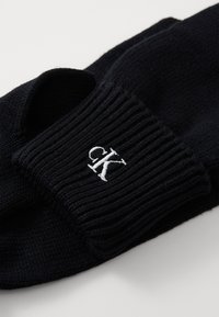 Mustad mustra marine sinised sokid piiriäärisega, millel on valge tikitud "ck" logo. Sile tekstuur ja mugav istuvus, sobivad igapäevaseks kandmiseks.