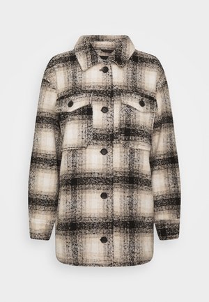 Giacca a quadri nera e crema con una texture simile alla lana. Presenta un colletto, chiusura con bottoni e due tasche sul petto.