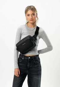 Borsa a tracolla nera di forma rettangolare, realizzata in materiale liscio, dotata di una tasca frontale con zip e di una tracolla regolabile.