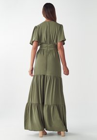 Maxikleid in Olivgrün mit kurzen Puffärmel, tailliertem Schnitt und gestuftem Rock. Verfügt über eine glatte Textur und ein einfaches Rückendesign.