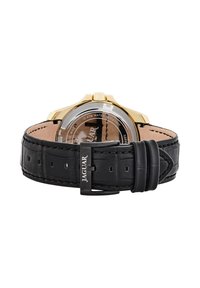 Reloj en tono dorado con correa de cuero negra. La correa presenta costuras y una hebilla plateada con el logo "JAGUAR". Diseño de esfera redonda clásico.