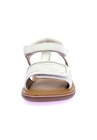 Sandali in pelle bianca con due cinturini regolabili, un design testurizzato sul cinturino frontale e una suola marrone. Con punta aperta e design piatto.