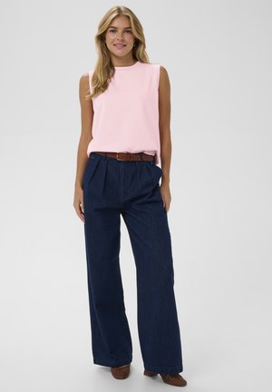 Rankovių neturinti rožinė palaidinė derinama su aukštu liemeniu plačiais tamsiai mėlynais džinsais. Rudas diržas pabrėžia liemenį; tekstūruoti rudi batai užbaigia įvaizdį.