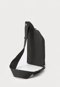 Zwarte, met rits gesloten slingbag van glad synthetisch materiaal, met een brede, verstelbare schouderriem en een eenvoudig, stijlvol ontwerp zonder zichtbare zakken.