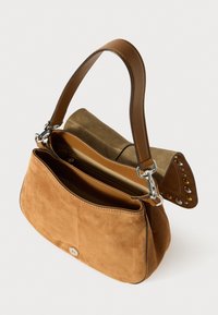 Sac à main en suédine marron avec un intérieur beige et olive, présentant un design structuré, une longue anse et des accents de clous décoratifs sur le rabat.