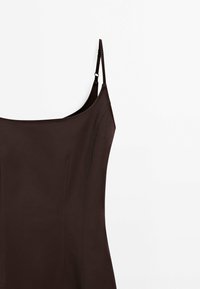 Brown sleeveless dress with thin straps, featuring a smooth texture and subtle stitching details along the bodice.
