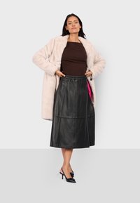 Světle růžový kabát z umělé kožešiny, hnědý přiléhavý top, černá kožená midi sukně s elastickým pasem a černé slingback podpatky. Hladká textura, jednoduchý design.