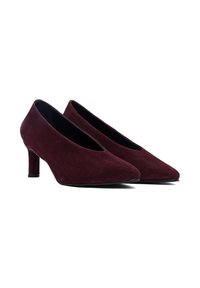 Zapatos de tacón alto de ante burdeos con puntera afilada y un tacón delgado. Los zapatos tienen una textura suave y un diseño minimalista.
