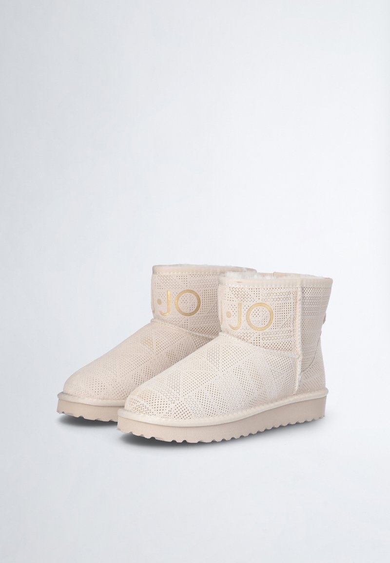 Beige Knöchelstiefel mit einem strukturierten, durchbrochenen Design, Kunstfellfutter und dezentem Gold-Branding an der Seite, mit einer Gummisohle.