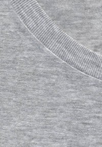 Grå sweatshirt stof med en glat overflade. Har en ribbet halsudskæring og blødt, let materiale. Subtil meleret mønster synlig.
