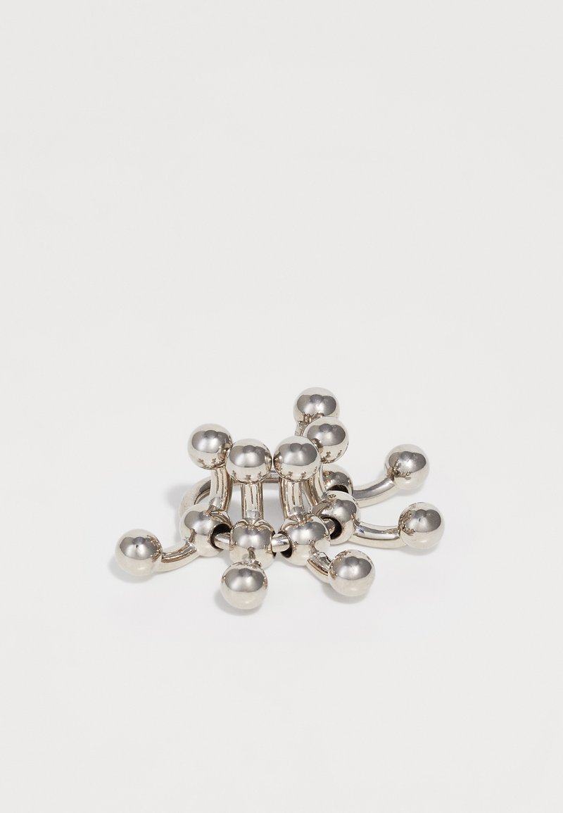 Pince à cheveux argentée ornée d'un groupe de perles sphériques reliées par des segments de métal incurvés, créant un design fascinant et moderne.