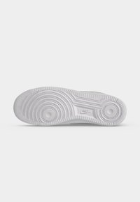 Λευκή σόλα παπουτσιού Nike με κυκλικά σχέδια πέλματος και το λογότυπο της Nike ανάγλυφο στη μέση σε απλό λευκό φόντο.