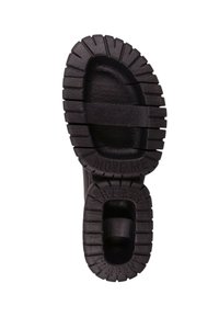 Suela de bota de goma negra con surcos y ranuras profundas para tracción, con acentos texturizados y "MUÉVEME" grabado en la parte inferior.