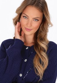 Maglione lavorato a maglia blu navy con texture a coste, scollatura rotonda e paillettes decorative sul davanti, completato da bottoni simili a gemme.
