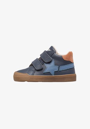 Zapatillas de cuero azul marino con dos correas de Velcro, acento en forma de estrella en azul, talón de ante color tostado y suela de goma texturizada. Diseño casual para niños.