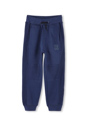 Pantalons de survêtement bleu marine en matériau doux avec des panneaux latéraux côtelés, taille avec cordon de serrage et logo "HUGO" imprimé sur la jambe gauche.