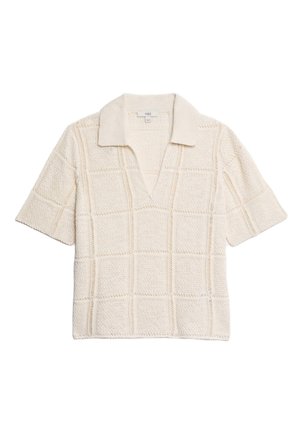 Polo à manches courtes couleur crème avec un motif en grille texturé, dotée d'un col en V et d'un col doux.