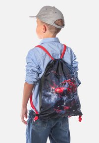 Zaino con cordoncino con grafica di un elicottero, tessuto nero, dettagli rossi e cordini rossi. Design casual adatto per bambini.